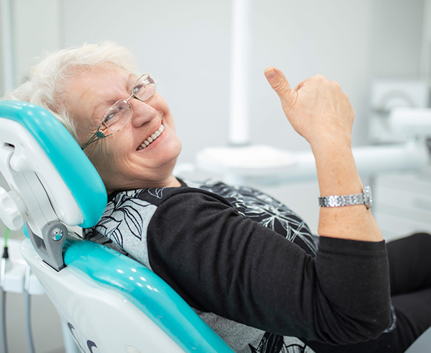 Happy older lady smiling with the during her dental appointment with a kois dentist